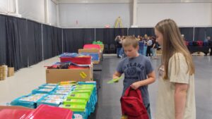 Two youth picking out school supplies at the free event