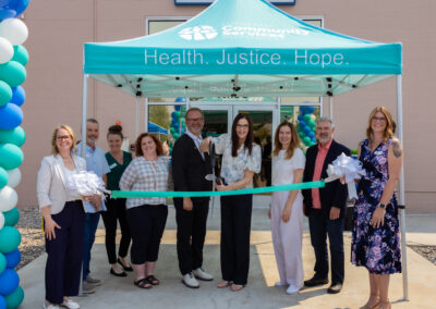 LCSNW leaders pose prepared to cut the ribbon outside the new Kennewick office