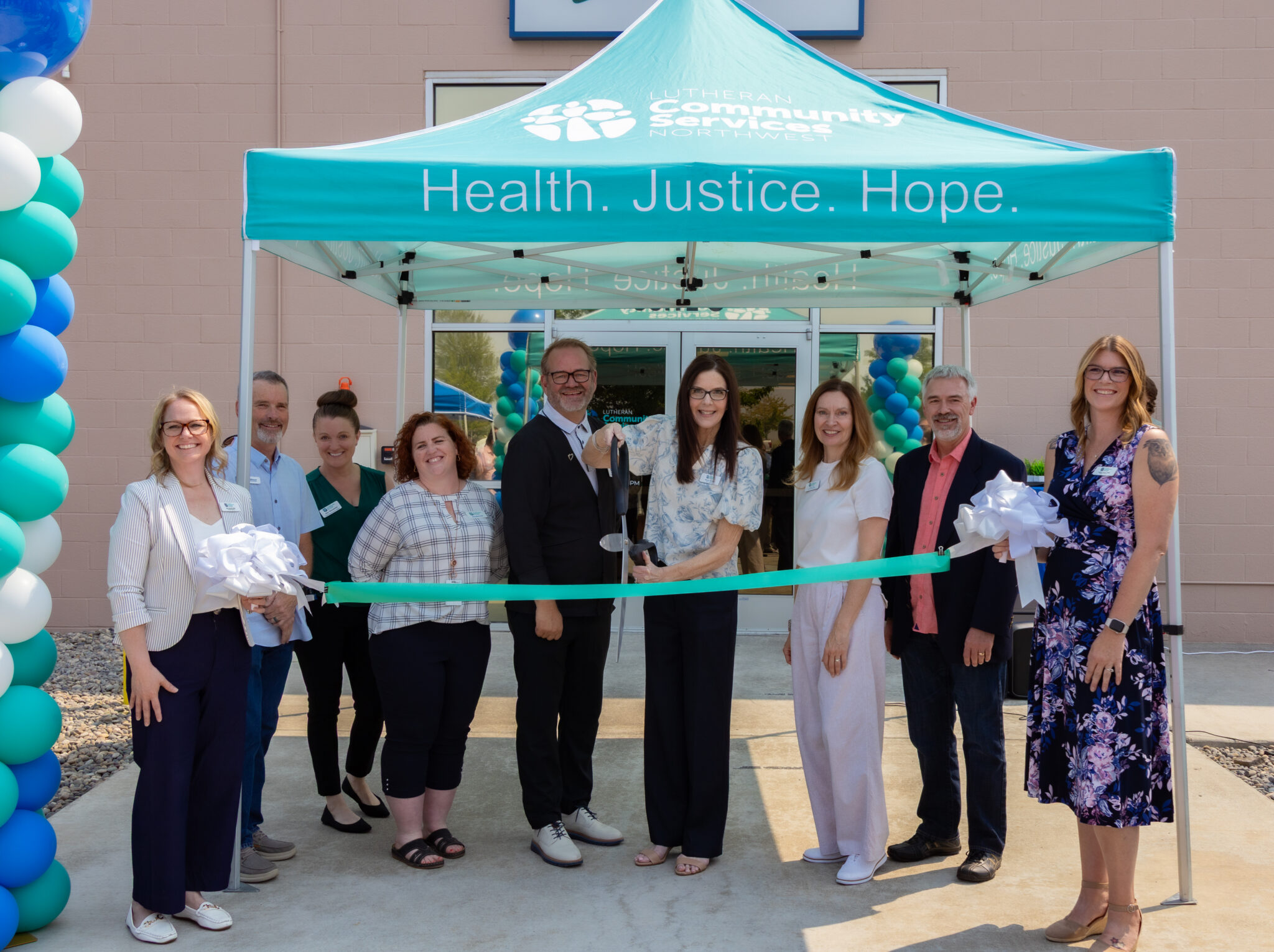 LCSNW leaders pose prepared to cut the ribbon outside the new Kennewick office